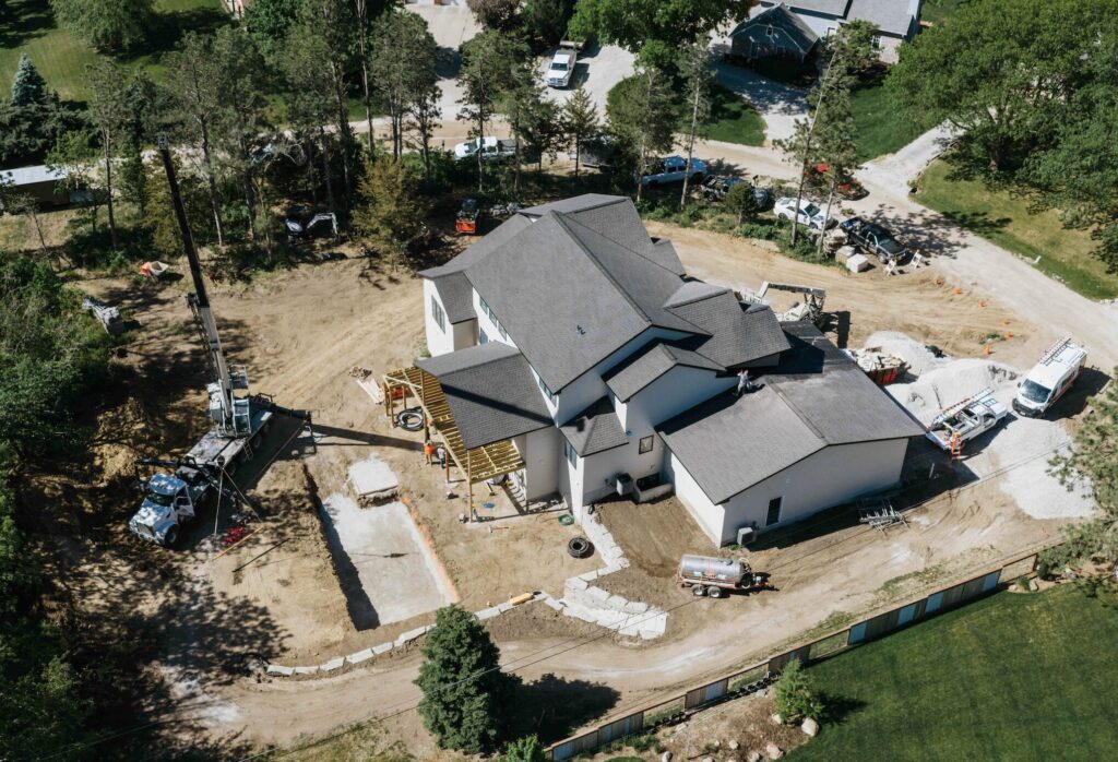 Aerial view of residential property during backyard pool excavation and hardscape build