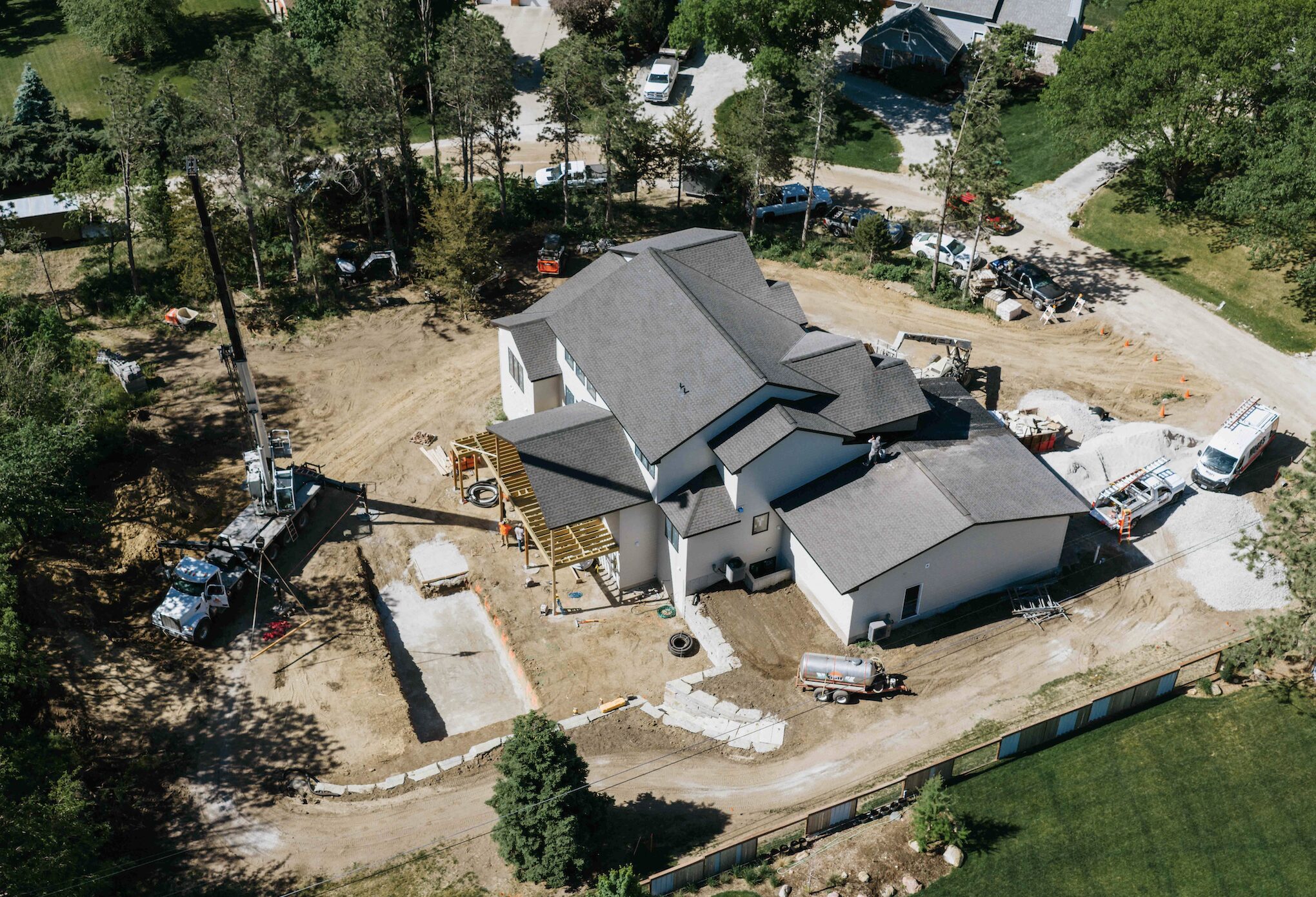 Aerial view of residential property during backyard pool excavation and hardscape build