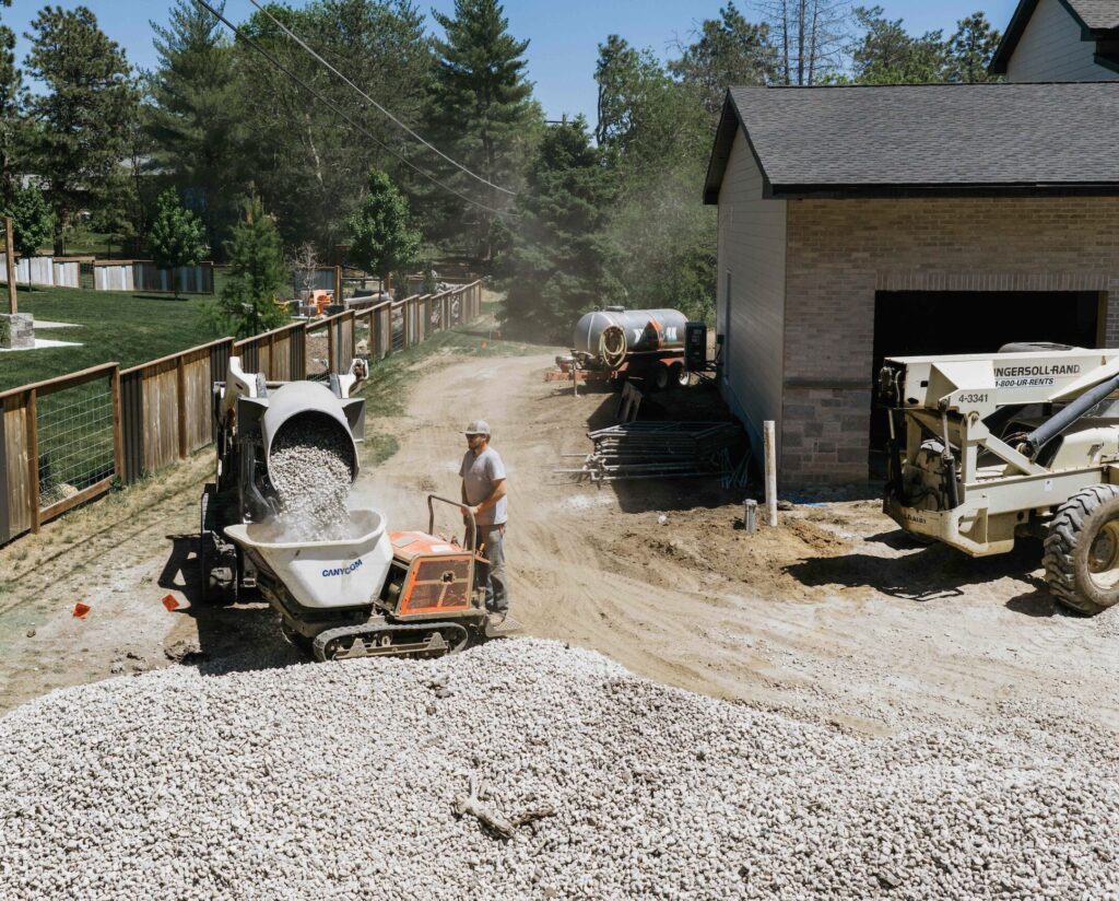 Skid steer loader and construction crew preparing ground for backyard pool installation