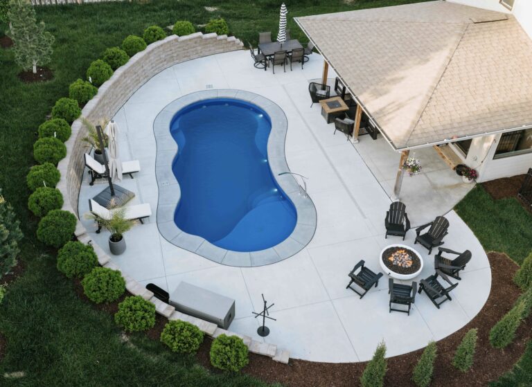 Top-down view of kidney-shaped pool with integrated spa and paver patio lounge