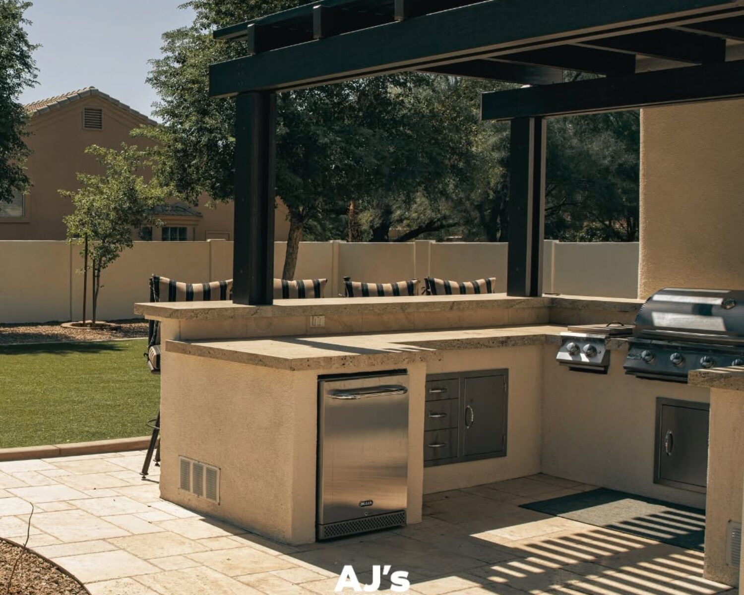 Custom pergola and modern outdoor kitchen island design by AJ's Landscaping Omaha