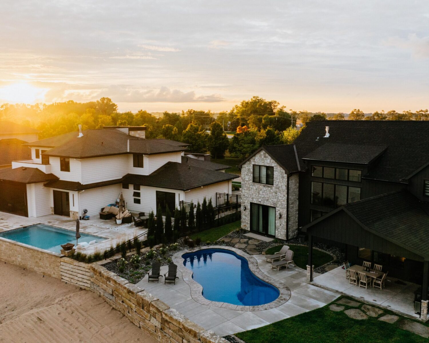 Sunset drone shot of a high-end luxury pool installation and complete backyard outdoor living transformation