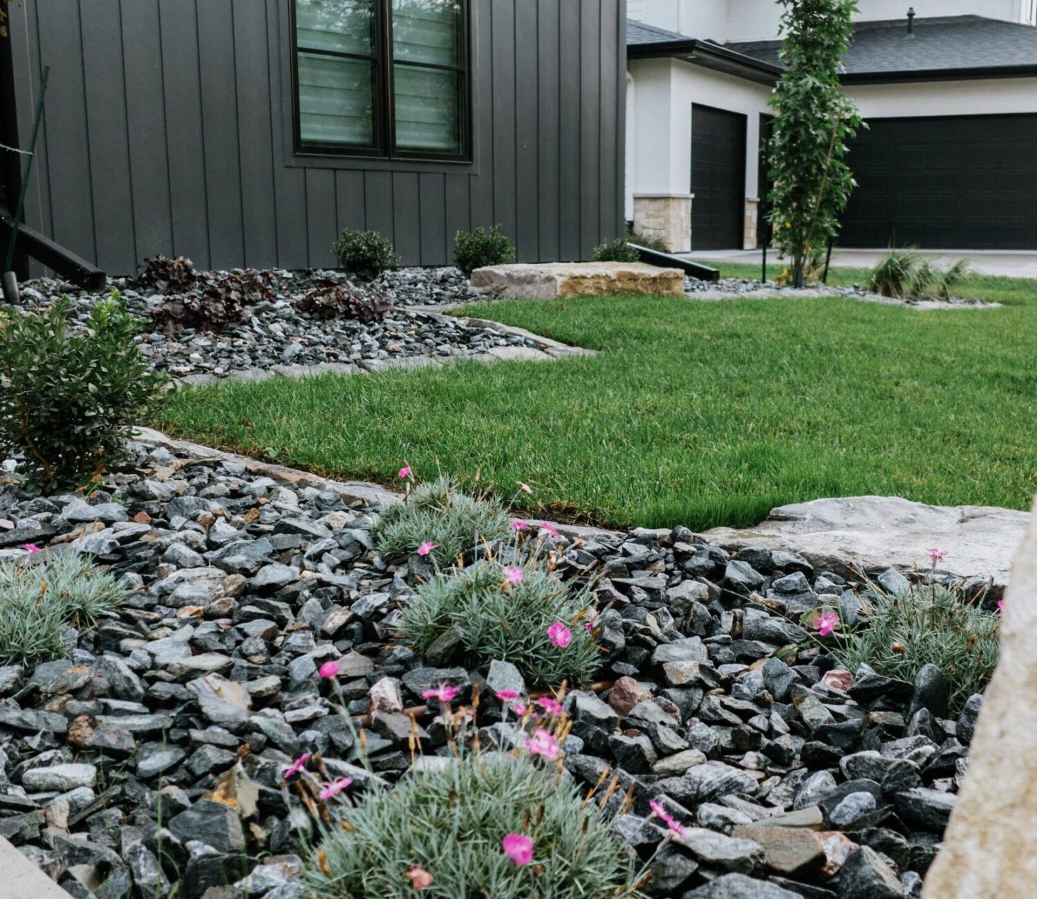 Dry creek bed drainage landscaping feature made with natural river rock and boulders
