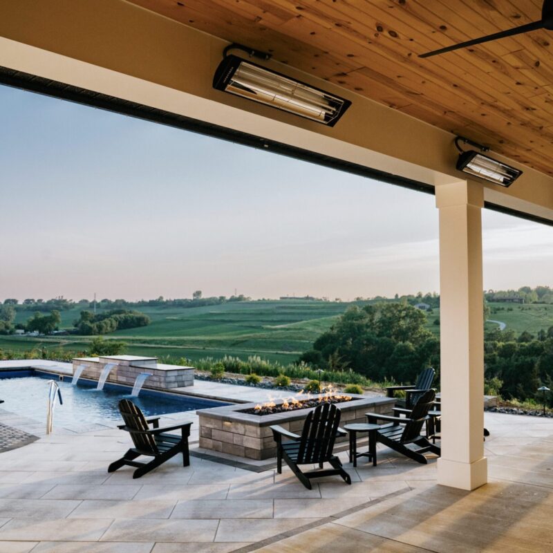 Covered outdoor pool patio with lounge seating, swimming pool, and open views creating a relaxing backyard retreat.