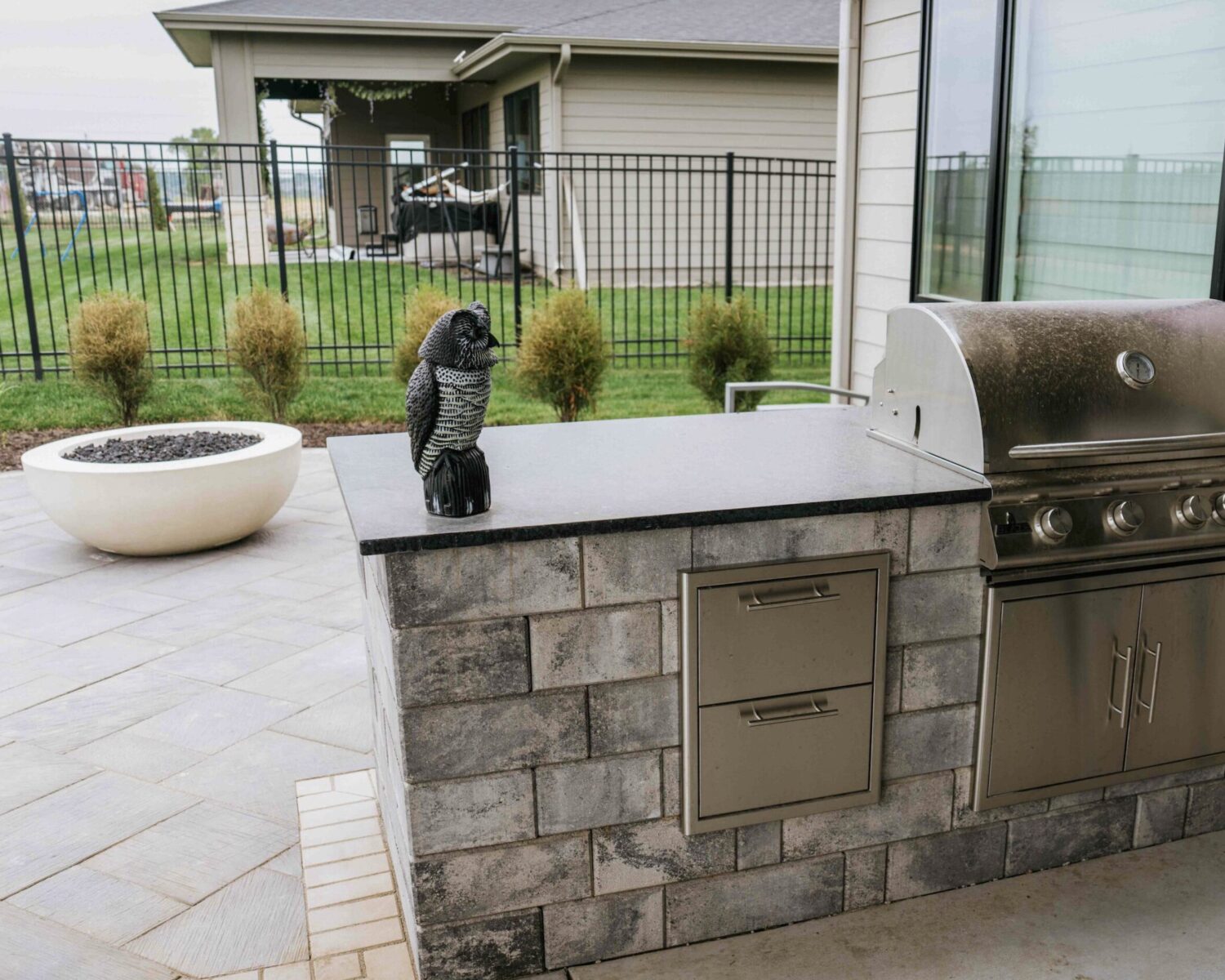 Custom outdoor kitchen with built-in grill, stone veneer, countertops, and patio space designed for backyard entertaining.