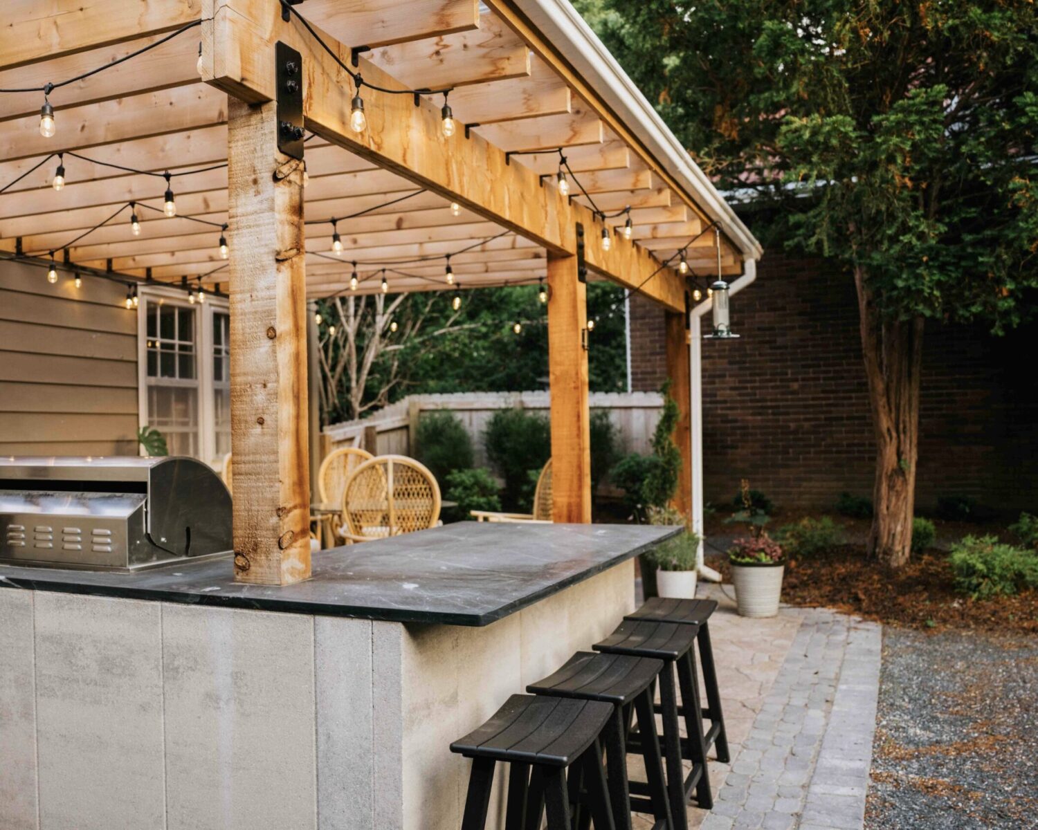 Spacious covered porch with built-in outdoor kitchen and bar seating for all-season backyard entertaining