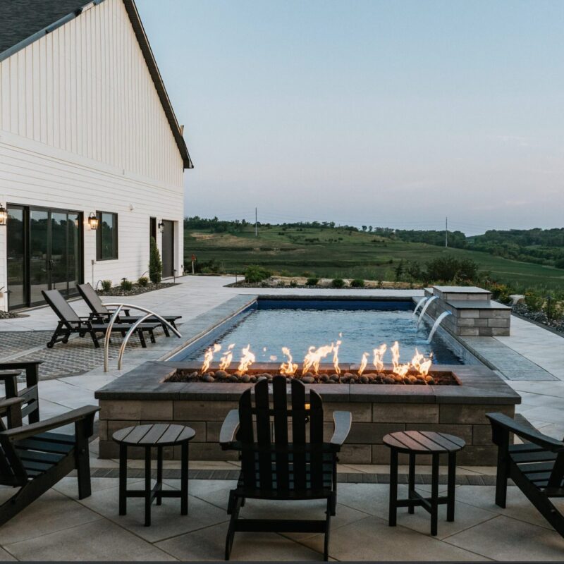 Modern backyard fire pit patio lounge overlooking scenic landscape at dusk