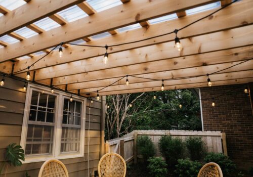 Custom wood patio pergola with integrated privacy wall and outdoor seating installed by professional landscaping contractor