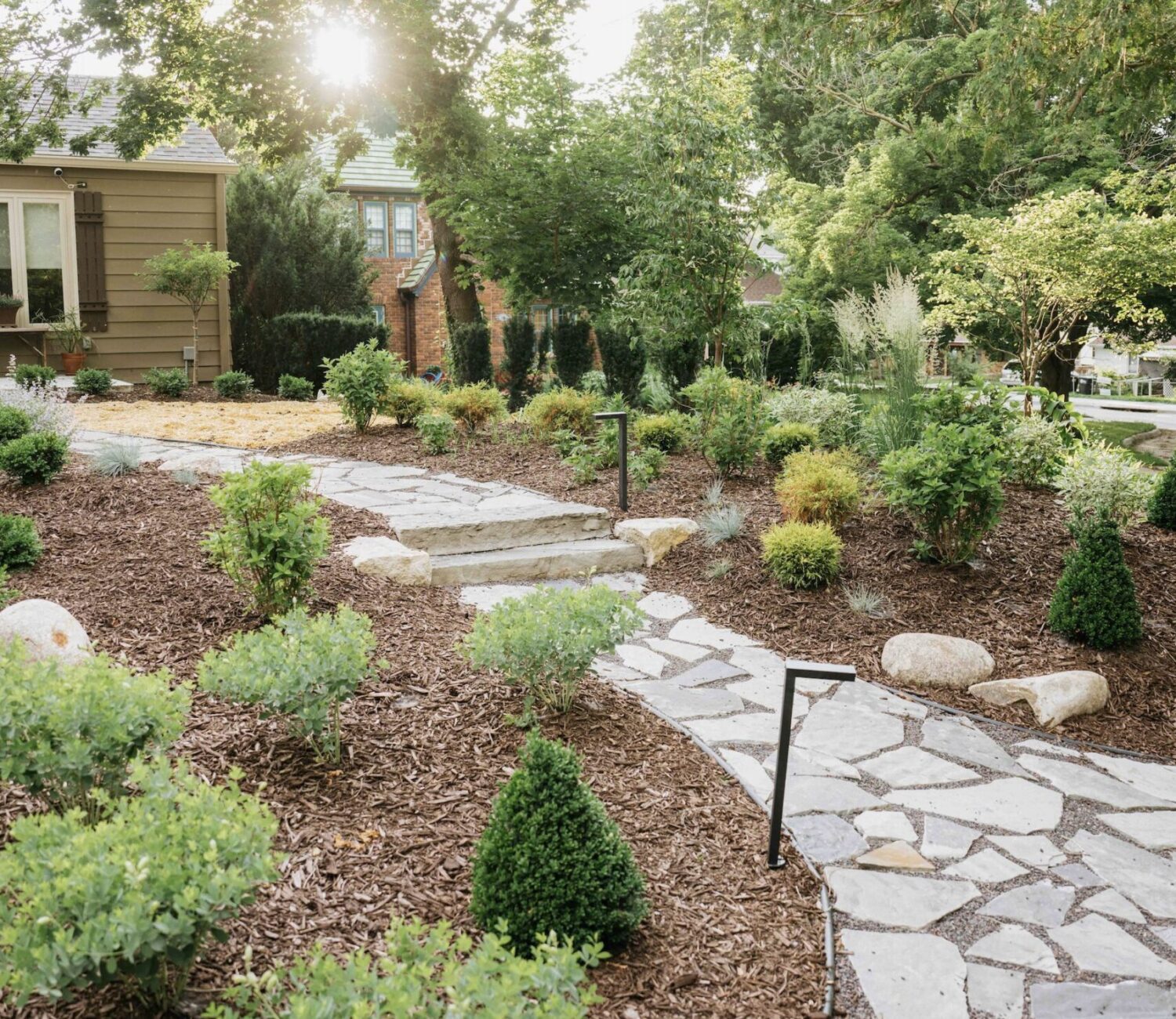 Winding stone path through a professional backyard garden design