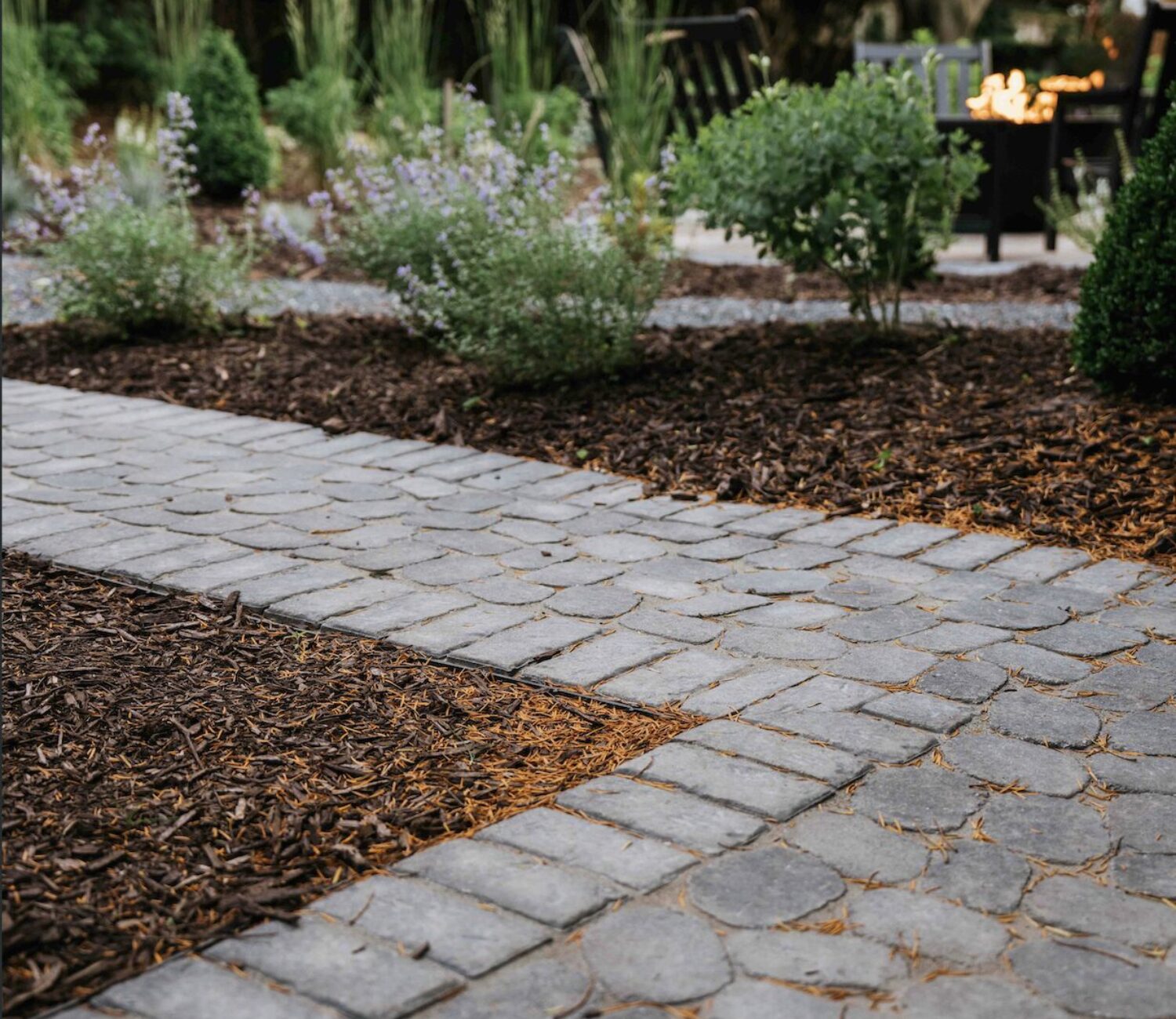 Custom paver walkway border transitioning from gravel path to stone patio