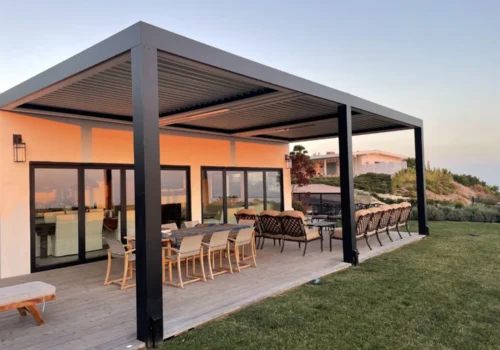 Modern black motorized louvered pergola covering a luxury outdoor dining and lounge patio in Omaha